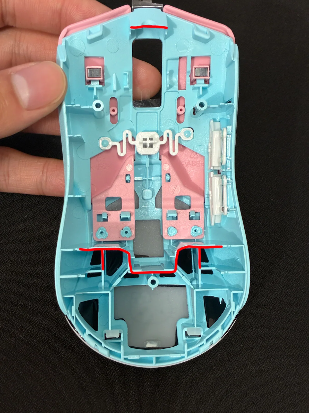 Red lines mark plastic to remove from the top shell