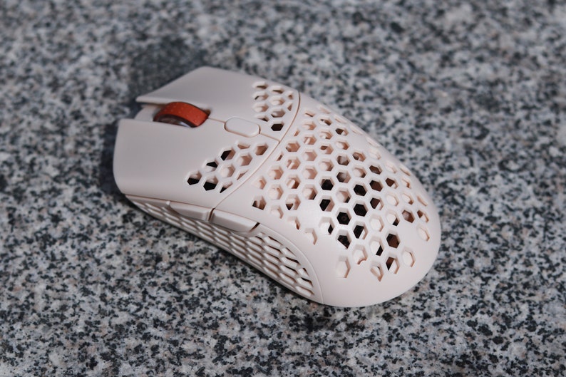 White Finalmouse UL2 wireless conversion with a red scroll wheel on a stone surface